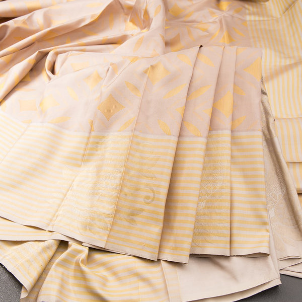 Beige Silk Saree With Stylish Yellow Patterns Adorning The Body And Grey Zari Border