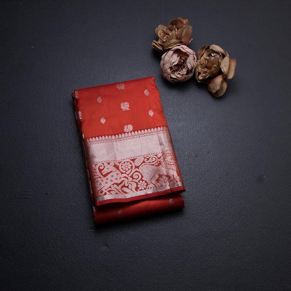 Reddish Orange Soft Silk Saree With Peacock And Mango Buttas In Silver Zari And Animal Motif On Border