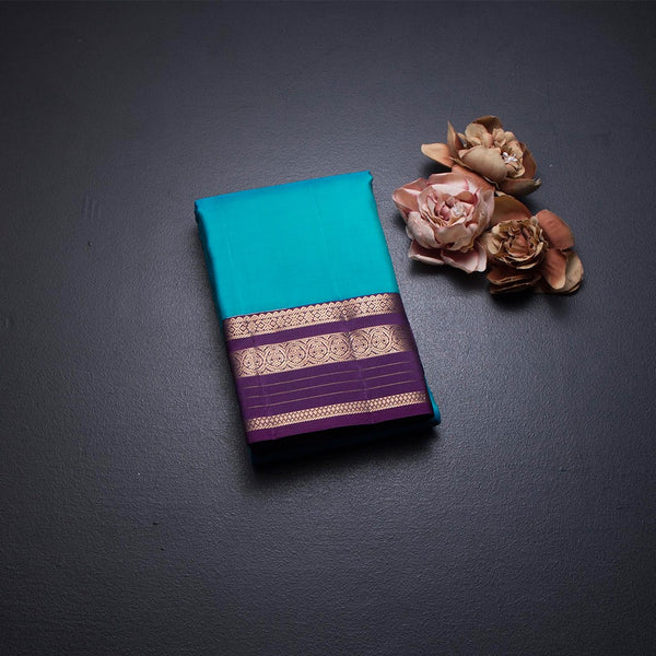 Peacock Blue Silk Saree With Chakra Buttas On The Body And Purple Zari Border