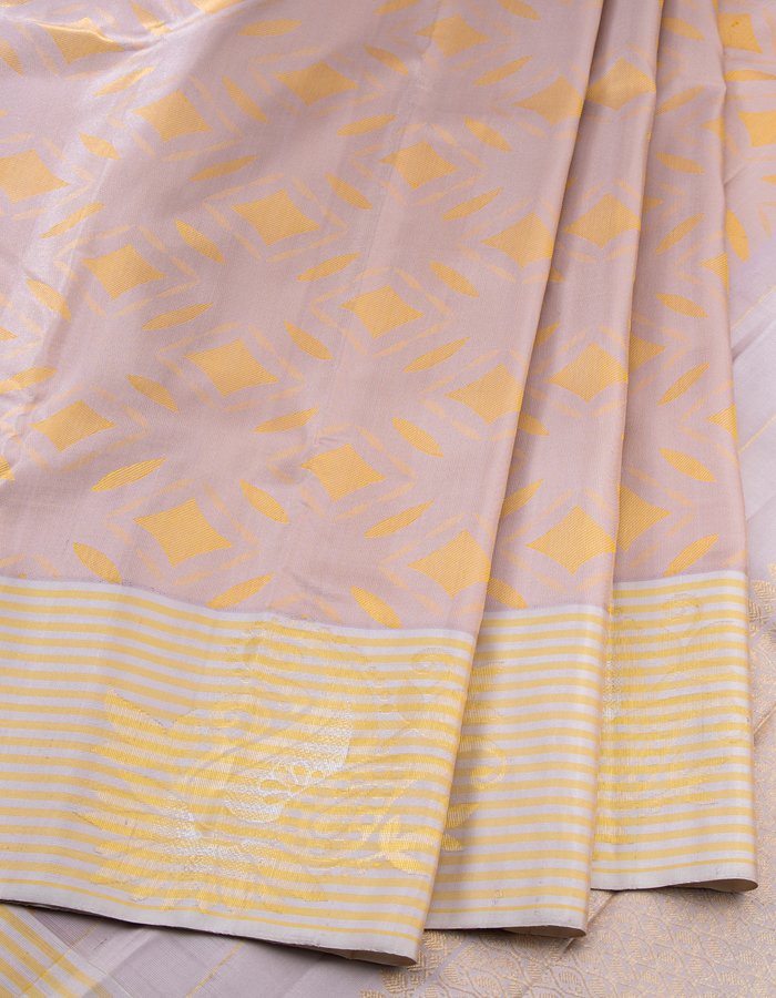 Beige Silk Saree With Stylish Yellow Patterns Adorning The Body And Grey Zari Border